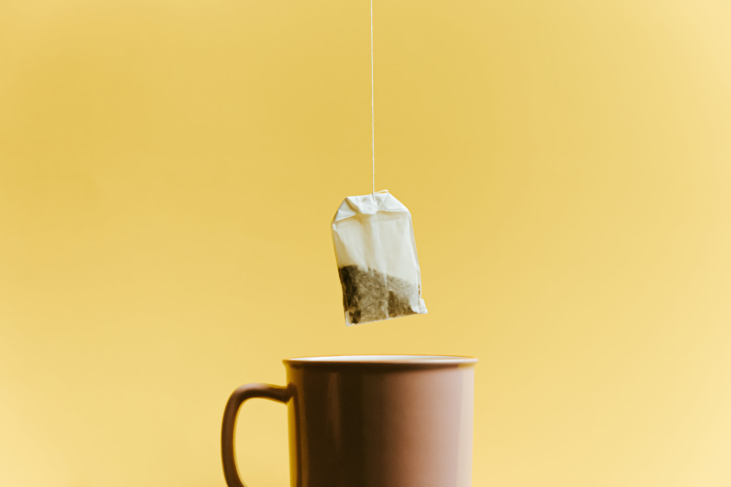 Mug-with-a-fresh-tea-bag-above-it